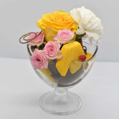 Composition florale en forme de coupe glacée dans les tons jaune, brun, rose et blanc