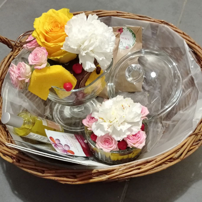 Panier contenant de petites compositions florales dans les tons jaune, rose et blanc, un sachet de fleurs comestibles, des stickers floraux, et des produits de beauté à base de fleurs