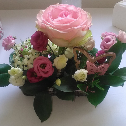 Centre de table floral pour un mariage dans les tons rose, vert et blanc, dans un contenant en écorce de bouleau