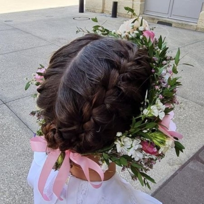 Petite fille portant une couronne de fleurs blanche et rose lors de sa première communion