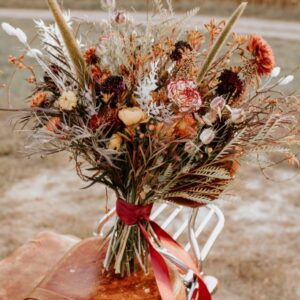 Bouquet de fleurs séchées debout sur une valise